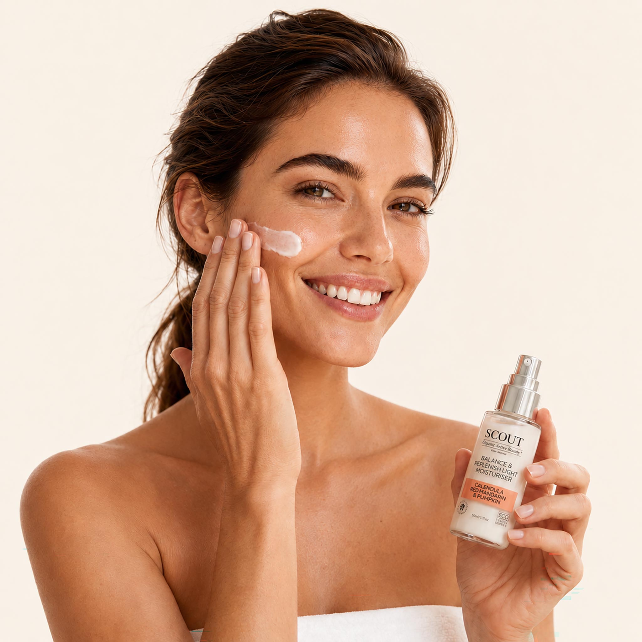 Woman applying skincare product with a bottle of Scout skincare on a beige background