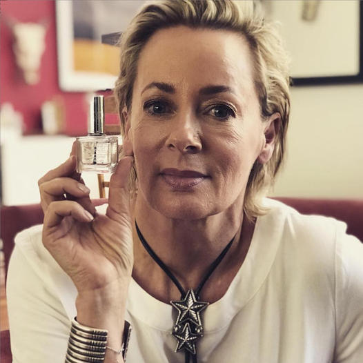 Amanda Keller holding a bottle of SCOUT Dual Base & Top Coat